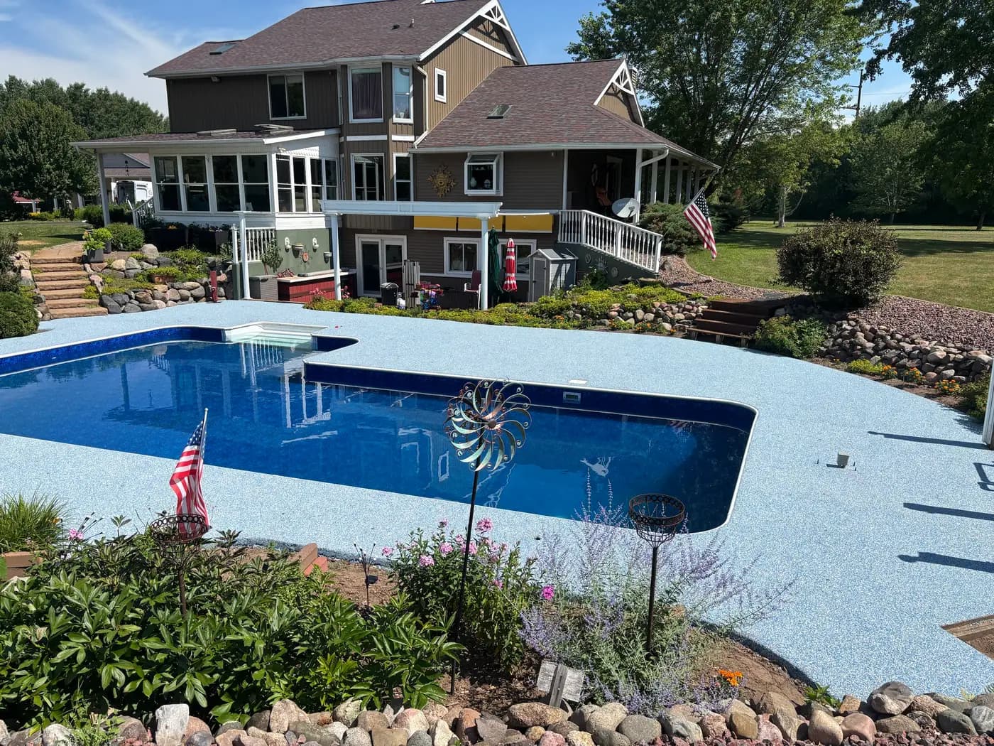 Light blue RevaFlex pool deck wrapping a rectangular pool, installed by WAMS