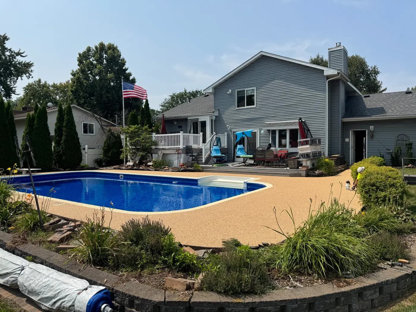 Tan RevaFlex pool deck installed by WAMS Stylish Coatings around a rectangular pool